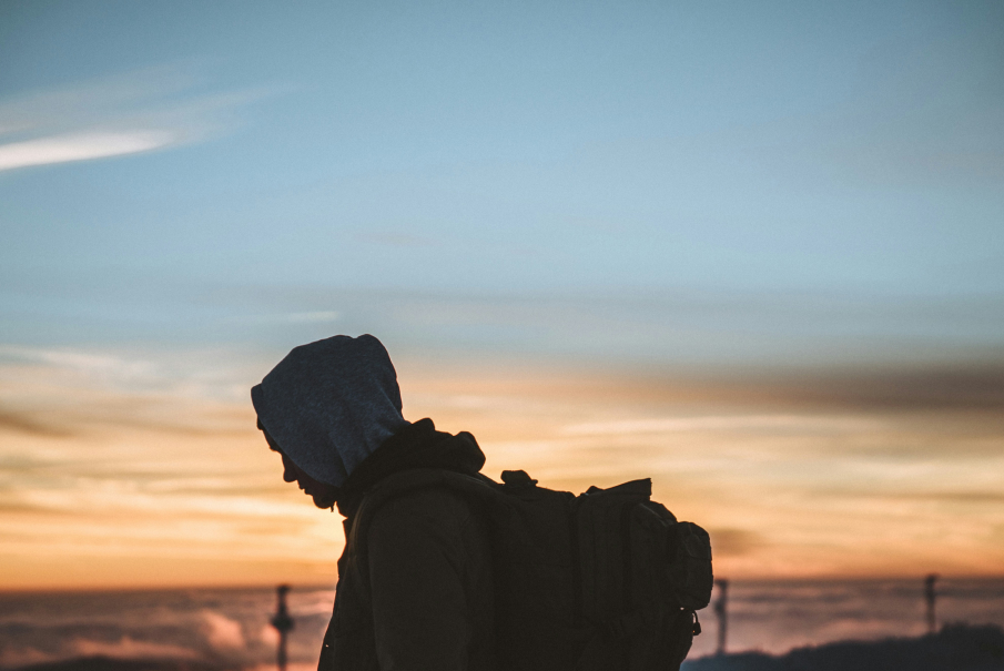 Silhuett av en person mot en himmel i solnedgang